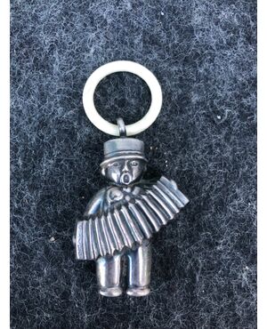 Silver baby rattle depicting an accordion player. Ivory ring.Europe.     