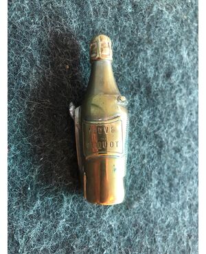 Scatolina portafiammiferi in ottone a forma di bottiglia di champagne ( Veuve Cliquot) con anche trancia-sigari.Francia