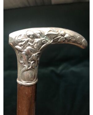 Silver stick with floral decoration and angels.     