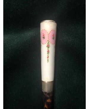 Evening stick with enameled silver knob with floral decorations and part of the tortoise barrel.     