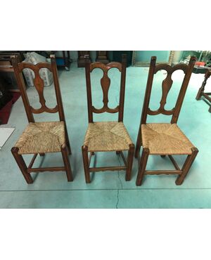 Three blond walnut chairs with straw covered seat.     
