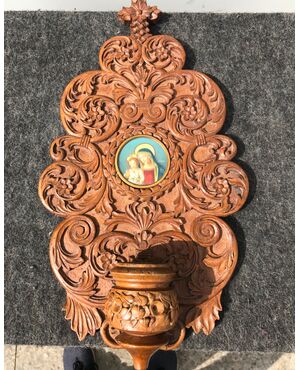 Acquasantiera in legno scolpito con motivi vegetali stilizzati e miniatura  Madonna con Bambino.
