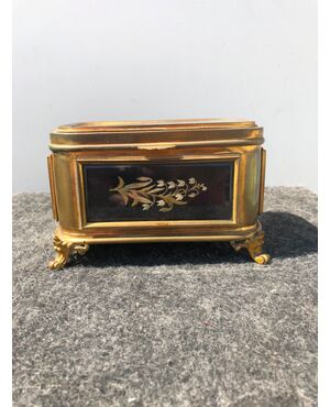 Brass jewelry box with panels embroidered with floral decorations.     