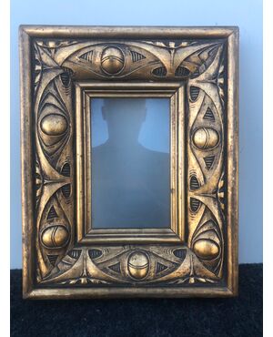 Carved and gilded wooden frame with art deco decorations.     