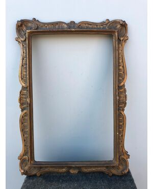 Carved and gilded wooden frame with stylized art-nouveau plant motifs.     
