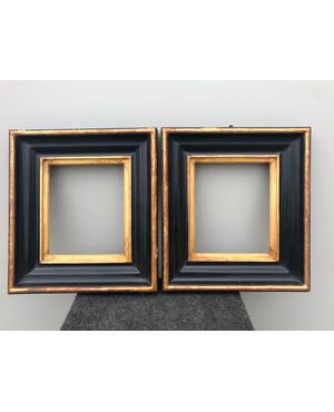 Pair of frames in carved, ebonized and gilded wood.     