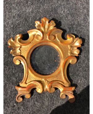 Carved and gilded wooden frame with plant and rocaille motifs.     
