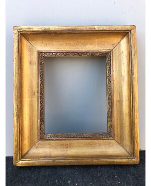 Frame in carved wood and gold leaf.     