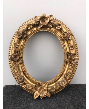 Carved and gilded wooden frame with flowers in relief.     