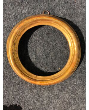 Round frame in carved and gilded wood.     