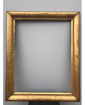 Large frame in carved wood and gold leaf with floral motifs.     