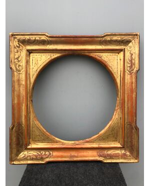 Frame in carved wood and gold leaf with plant decorations.     