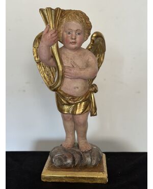 Angelo reggicornucopia in legno intagliato dorato. XVIII secolo.