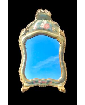 Specchiera in legno intagliato e laccato con motivi floreali.