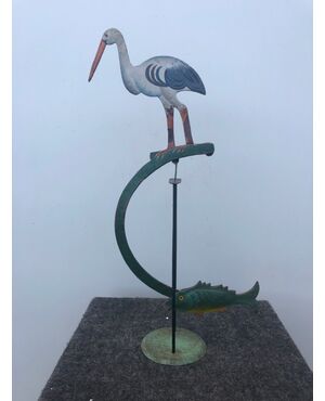 Painted metal game depicting bird with counterweight fish, tilting on base.     