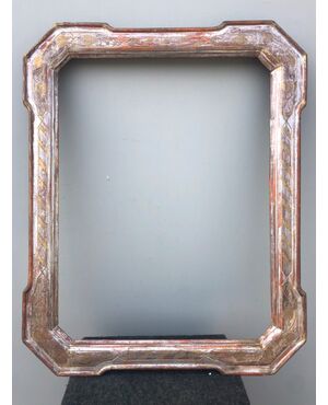 Cabaret frame in carved and silvered wood with golden stylized vegetal details.     