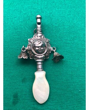 Baby rattle in silver with a child&#39;s face and mother-of-pearl handle.     