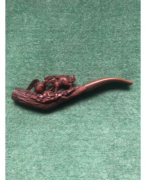 Carved wooden pipe depicting an eagle and a fox competing for a fawn as prey.     