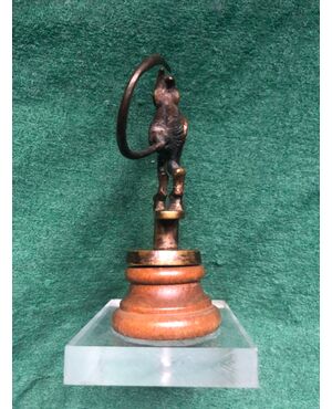 Bronze statue mounted on a wooden base depicting a devil making raspberry.     