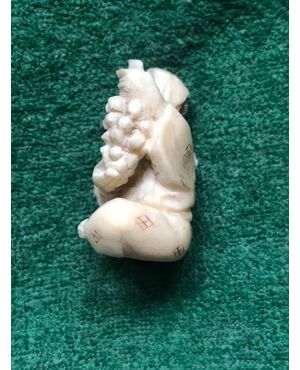 Ivory netsuke &#39;with character sitting with bunch of grapes. Japan.     