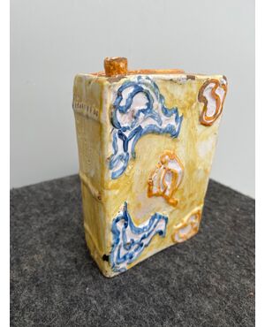 Book-shaped bottle-flask with rocaille decorations in relief.Manufacture of Castelli d&#39;Abruzzo.     