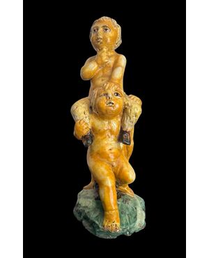 Scultura in maiolica policroma con due fanciulli che reggono un fauno.Nicola Giustiniani.Napoli.