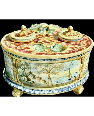 Calamaio in maiolica a 4 piedi con presa a forma di foglia e decoro con medaglioni con paesaggi e personaggi.Manifattura Minghetti.Bologna.