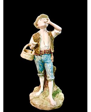Polychrome majolica sculpture depicting a peasant drinking eggs. Ginori.