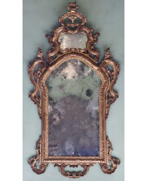 Carved, sculpted, and gilded wooden mirror. Venice, mid-18th century.