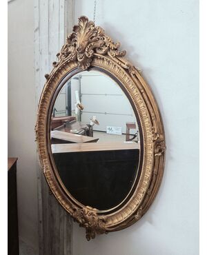 Large oval gilded wooden mirror with a cyma with a curl
