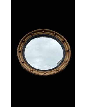 Specchio convesso ‘occhio della strega’ con cornice in legno dorato.