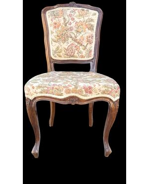 Four walnut chairs with floral pattern carvings.