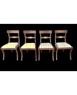 Four walnut chairs with geometric pattern decoration.