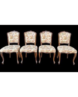 Four walnut chairs with floral pattern carvings.