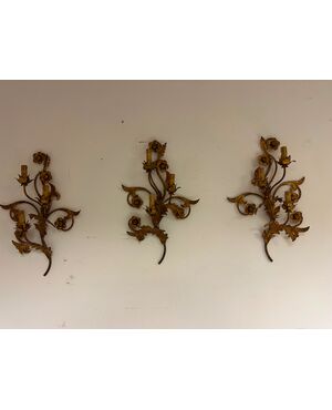 Three gilded metal sconces with floral motifs. 19th century