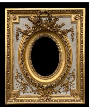 Cornice in legno intagliato con trofei,ghirlande,motivi vegetali e geometrici.