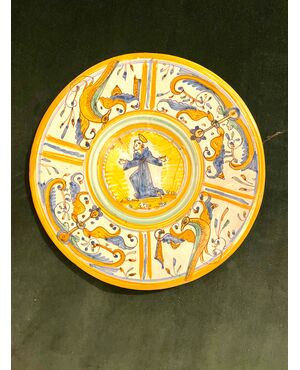 Majolica cutting board with Raphaelesque quarter decoration and central round with figure of Saint Deruta manufacture.     