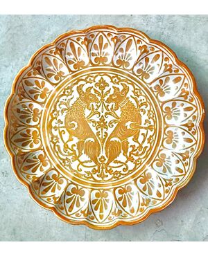 Plate-barberry, decorated in luster with fantastic animals in the umbo and geometric motifs on the brim. Manufacture Grazia, Deruta.     