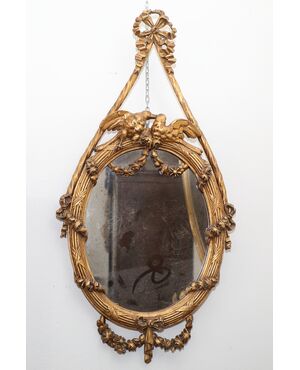 Pair of oval mirrors in gilded wood with a pair of birds     