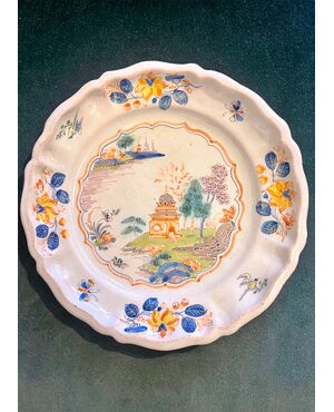 Majolica plate decorated with floral motifs and architectures, called al &#39;casotto&#39;. Ferniani manufacture, Faenza.     