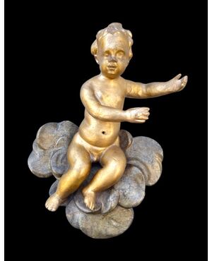 Figure of a putto in carved and gilded wood on painted clouds.Liguria     