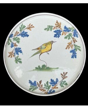 Raised plate-cutting board in majolica with bird decoration and plant motifs. Manufacture of Pavia.     
