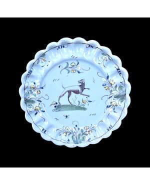 Berettina majolica plate with ribbed brim and floral motif decoration with a dog in the center.     