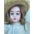 Doll with bisque head and original dress. 1902 initials and numerical elements.     
