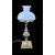 Lampada in ottone con corpo rastremato e bracci laterali rocaille.Cappello in vetro lattimo.
