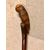 Wooden stick in a single piece with a knob representing a parrot.     