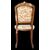 Four walnut chairs with floral pattern carvings.