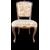 Four walnut chairs with floral pattern carvings.