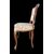 Four walnut chairs with floral pattern carvings.