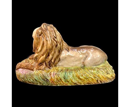 Scultura in porcellana policroma raffigurante leone accovacciato.Manifattura Samson.Francia.